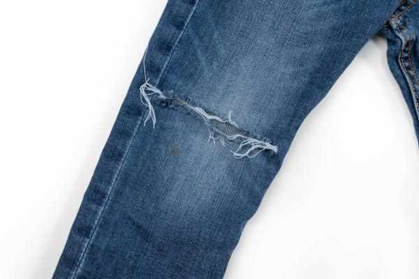 repareren van een broek met reparatiedoek en een kruisteek